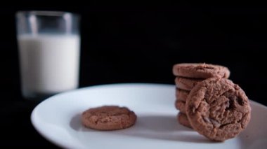 Siyah arka planı olan bir kurabiye bardağına daldırmak.