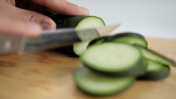 Mains tranchant du concombre frais sur une planche à découper en bois — Video