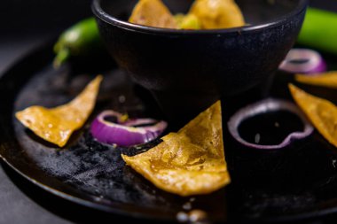 Meksika Comal 'ında tortilla cipsi, kırmızı biber ve soğan dilimleri.