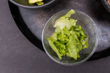 Geleneksel Meksika comalının üzerinde bir kase doğranmış marul.