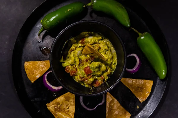 Miska guacamole na meksykańskim comal ozdobiona chipsami i warzywami tortilla — Zdjęcie stockowe