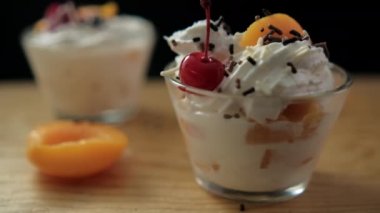 Bir fincan şeftali ve krema siyah arka planlı tahtanın üzerinde.