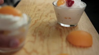 Ahşap yüzeyde, bulanık yüzeyi olan şeftali ve krema kapları.