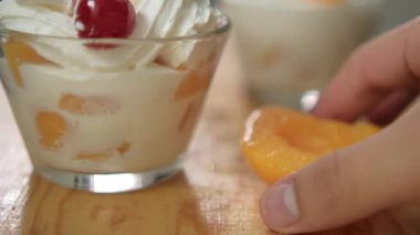 Ahşap yüzeyde bir fincan lezzetli şeftali ve krema.