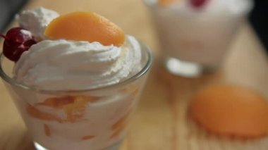 Ahşap yüzeyde siyah yüzeyi olan şeftali ve krema kapları.