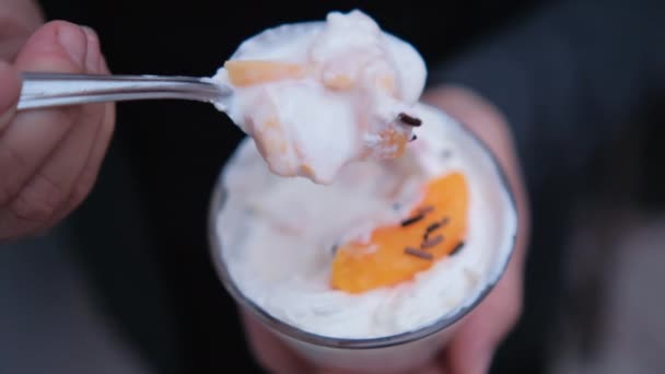 Руки, що тримають ложку і чашку персиків і вершків — стокове відео