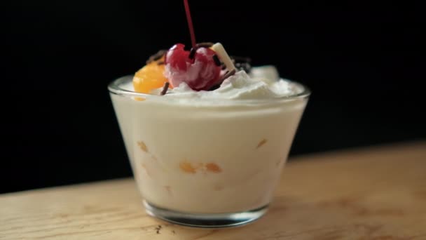 黒を基調とした木の板の上の桃とクリームのカップ — ストック動画