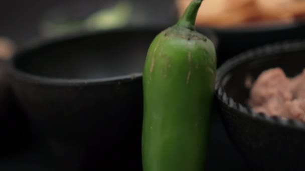 Papryka chili opierająca się o miski z wiórkami tortilla i smażoną fasolą — Wideo stockowe