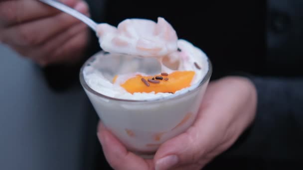 Mãos segurando colher e xícara de pêssegos e creme — Vídeo de Stock