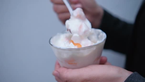 手拿着汤匙和杯淡蓝色背景的桃子和奶油 — 图库视频影像