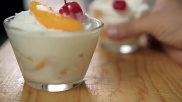 Cups of delicious peaches and cream on wooden surface — Stock Video