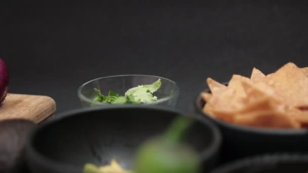 Papryka chili opierająca się o miski z wiórkami tortilla i smażoną fasolą — Wideo stockowe