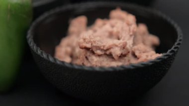Acı biber bir kase tortilla cipsi ve yeniden kızartılmış fasulyeye dayanır.