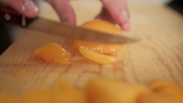 Нарізання рук очищеними персиками на обробній дошці — стокове відео