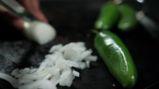 Handen snijden ui en groene chili pepers op een traditionele Mexicaanse comal — Stockvideo