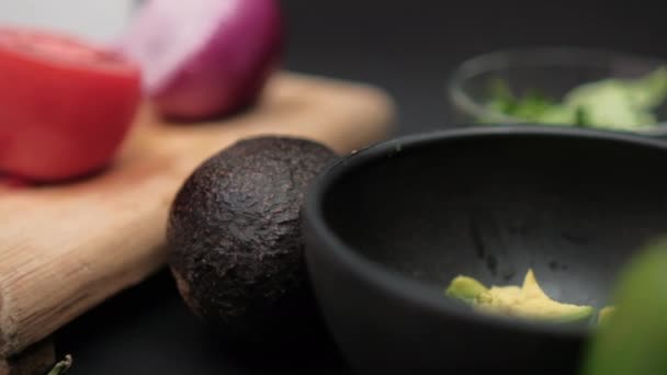 Papryka chili i miski posiekanej awokado i fasoli na czarnej powierzchni — Wideo stockowe