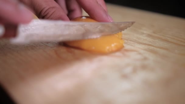 Hænder skære skrællede ferskner på et skærebræt – Stock-video