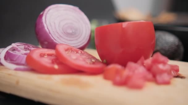 带有模糊背景的木制切菜板上的切碎西红柿和洋葱 — 图库视频影像