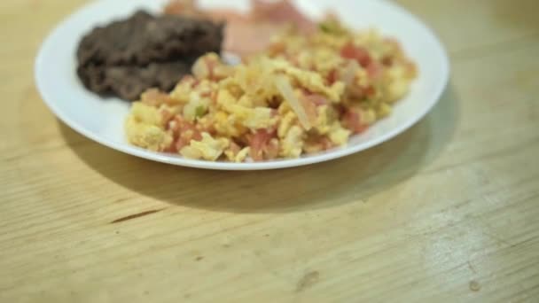 メキシコ風の卵、ベーコン、白皿の上で揚げた豆 — ストック動画