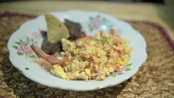 Μεξικάνικου τύπου αυγά, μπέικον, και refried φασόλια με τηγανητές πατάτες τορτίγια σε λευκό πιάτο — Αρχείο Βίντεο