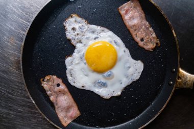 Lezzetli kızarmış yumurta ve pastırma kızartma tavasında şerit.