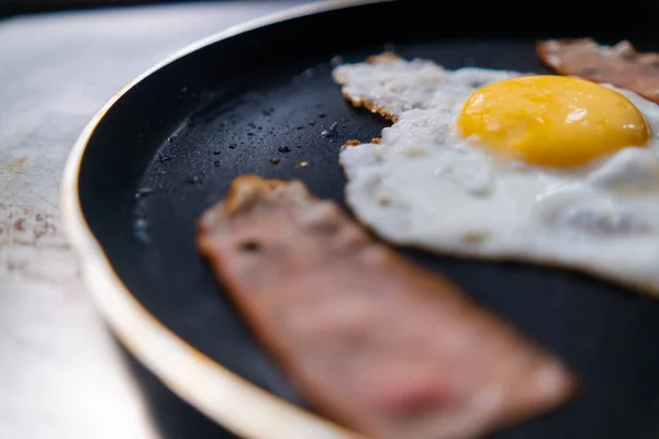Utsökt stekt ägg och baconremsa på stekpanna — Stockfoto