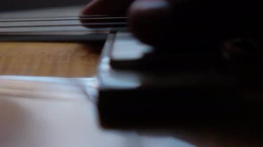 El, klasik elektro gitarın tellerine hafifçe dokunuyor.