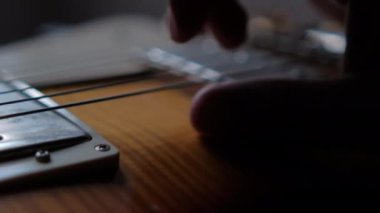 Erkek el, klasik ahşap gitar tıngırdatıyor.
