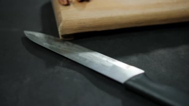 Karanlık yüzeyde siyah saplı uzun bıçak