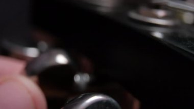Parmaklar klasik elektro gitarın dönüş tuşlarına dokunuyor