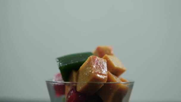 Kopp med färsk frukt pasta kuber med vit bakgrund — Stockvideo