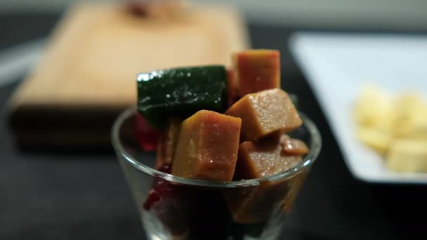 Tazza di cubetti di pasta di frutta fresca sulla superficie nera — Video Stock