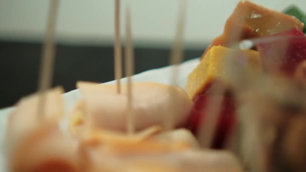 Šunkové závitky a barevné nakrájené ovoce pasta s šedým pozadím — Stock video