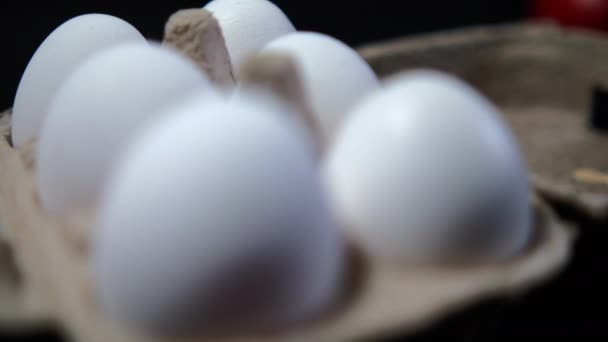Zes verse witte eieren in karton boven zwarte achtergrond — Stockvideo