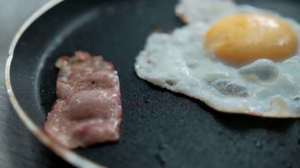 Delicioso huevo frito y tira de tocino en una sartén — Vídeo de stock