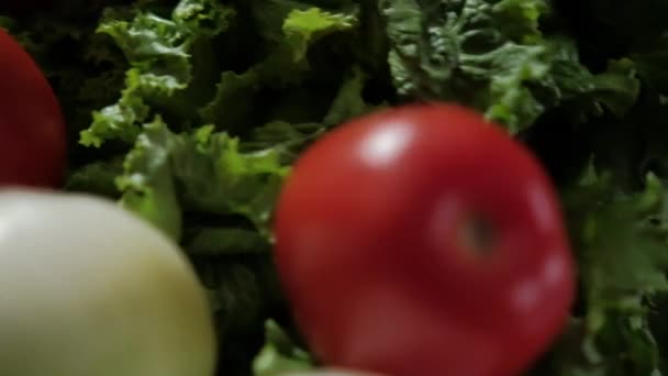 Fresh tomato rolling down from big lettuce with black background — Stock Video