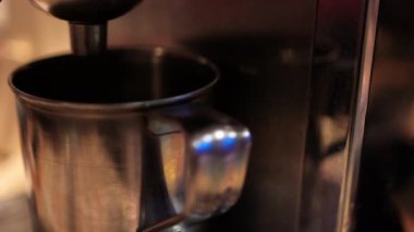 Metal bardak espresso makinesiyle doldurulmaya hazır.