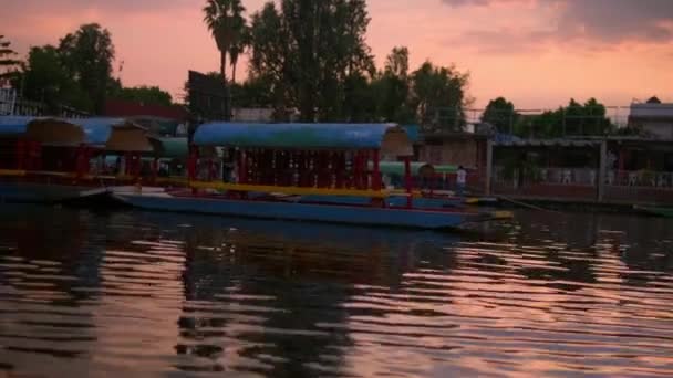 Trajineras coloridos tradicionais no lago Xochimilco sob belo céu pôr do sol — Vídeo de Stock
