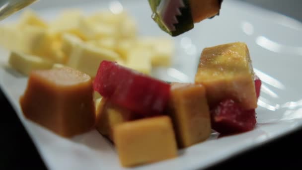 Frisch gewürfelte Fruchtpaste und Cheddar-Käsewürfel auf einem Teller — Stockvideo