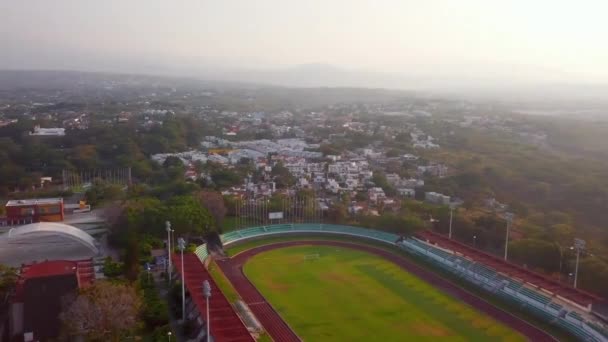 Vue aérienne de la piste de course et du terrain de soccer avec des montagnes au loin — Video