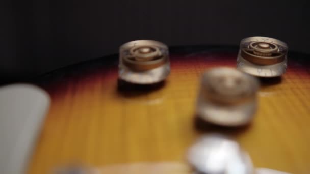 Volume and tone controls of classic wooden-like electric guitar — Stock Video