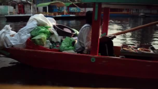 Vrouwelijke voedselleverancier in rode en groene boot in Xochimilco meer — Stockvideo