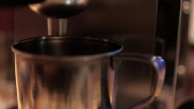 Metal bardak espresso makinesiyle doldurulmaya hazır.