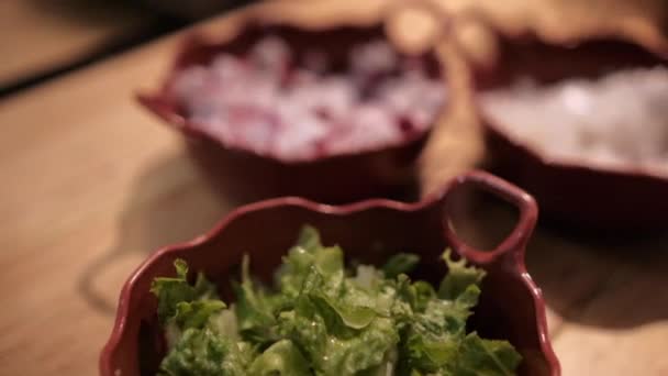 Вкусный традиционный мексиканский позоле и приправы на деревянном столе — стоковое видео