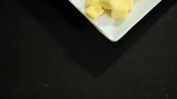 Šunkové závitky, nakrájená ovocná pasta, kostky sýra a ořechy na bílém talíři — Stock video