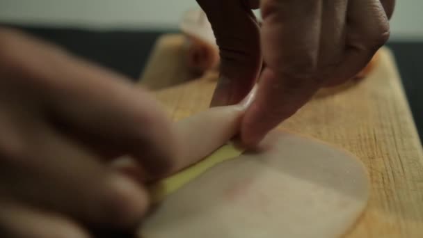 Mãos rolando fatias de presunto de peru acima da placa de corte — Vídeo de Stock