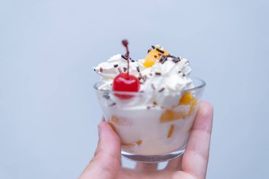 El ele tutuşan şeftali ve krema açık mavi arkaplan