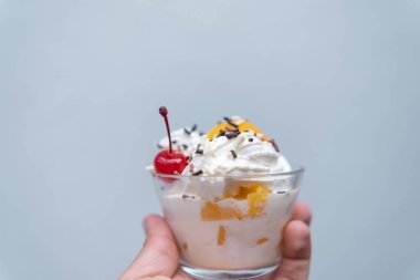 El ele tutuşan şeftali ve krema açık mavi arkaplan