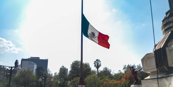 Mexican flag flying at half-mast with bright sky as background — Stock Photo, Image