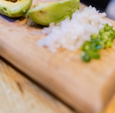 Soyulmuş avokado, doğranmış soğan ve kırmızı biber.